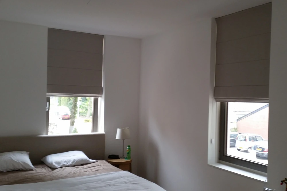 Grijze blackout vouwgordijnen in een slaapkamer